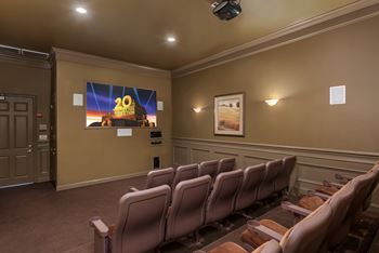 A row of seats in a room with a screen showing the number 20.